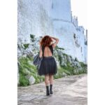 abito nero elegante senza maniche, caratterizzato da un corpetto in pizzo con scollo alto e una gonna a balze in tulle