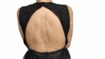 abito nero elegante senza maniche, caratterizzato da un corpetto in pizzo con scollo alto e una gonna a balze in tulle